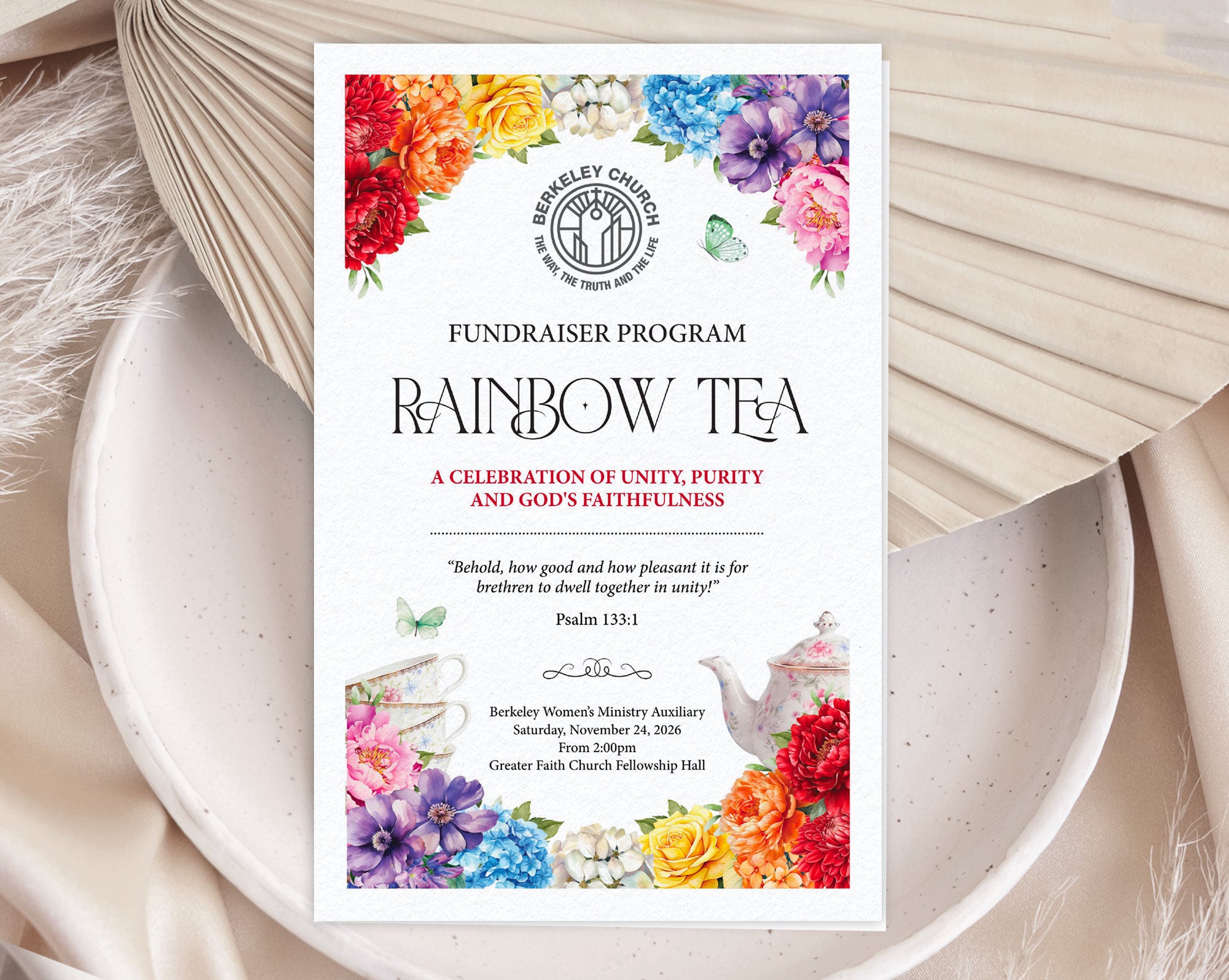 A printed fundraiser folded 11 x 8.5 program card for 'Rainbow Tea' church event styled flat-lay on a ceramic dish with dried flowers.