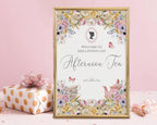 12 x 18 afternoon Tea Welcome Sign with Pastel Flowers, Teapot, Tea Cups, Regency Cameo in a gold frame leaning up against a pink wall next to a wrapped gift