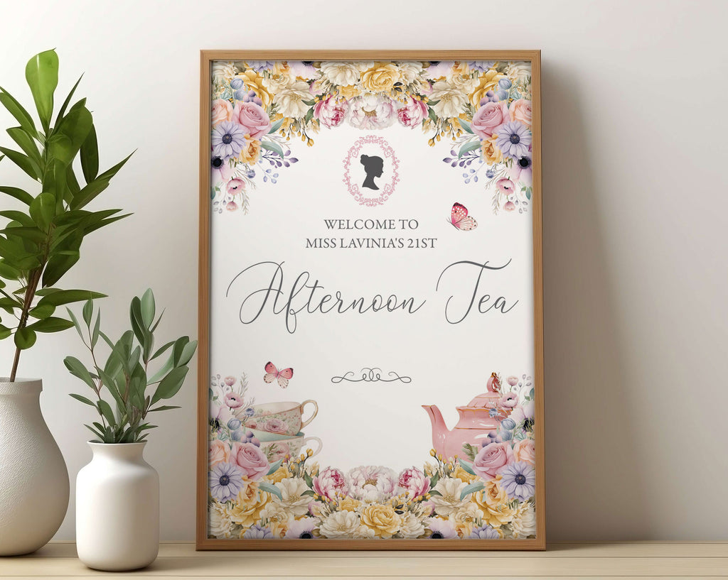 Small Bridgerton inspired afternoon tea digital welcome sign in a wooden frame leaning up against a beige wall next to some greenery in vases