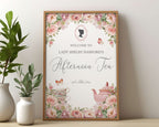 pretty pink flower sign for an Afternoon Tea with regency style cameo, teapot and butterflies in a wooden frame leaning against a beige wall next to greenery in a vase