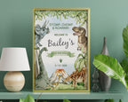 a 12 x 18 dinosaur party welcome sign in a gold frame on a shelf, leaning up against a green wall with a lamp and some greenery