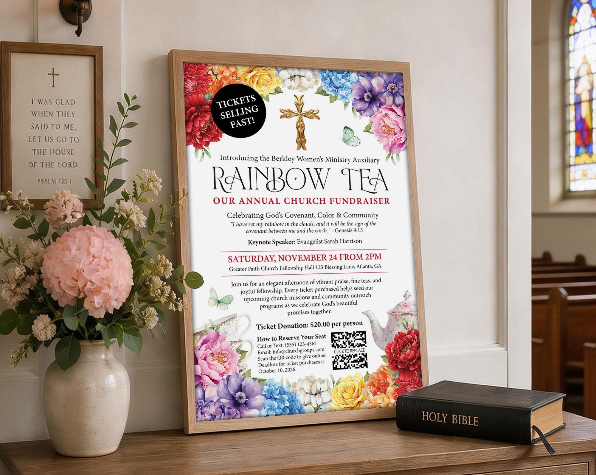 a 12 x 18 fundraising poster with QR code for a Church Rainbow Tea, in a wooden frame leaning up against a wall next to some flowers in a vase and a religious sign on the wall