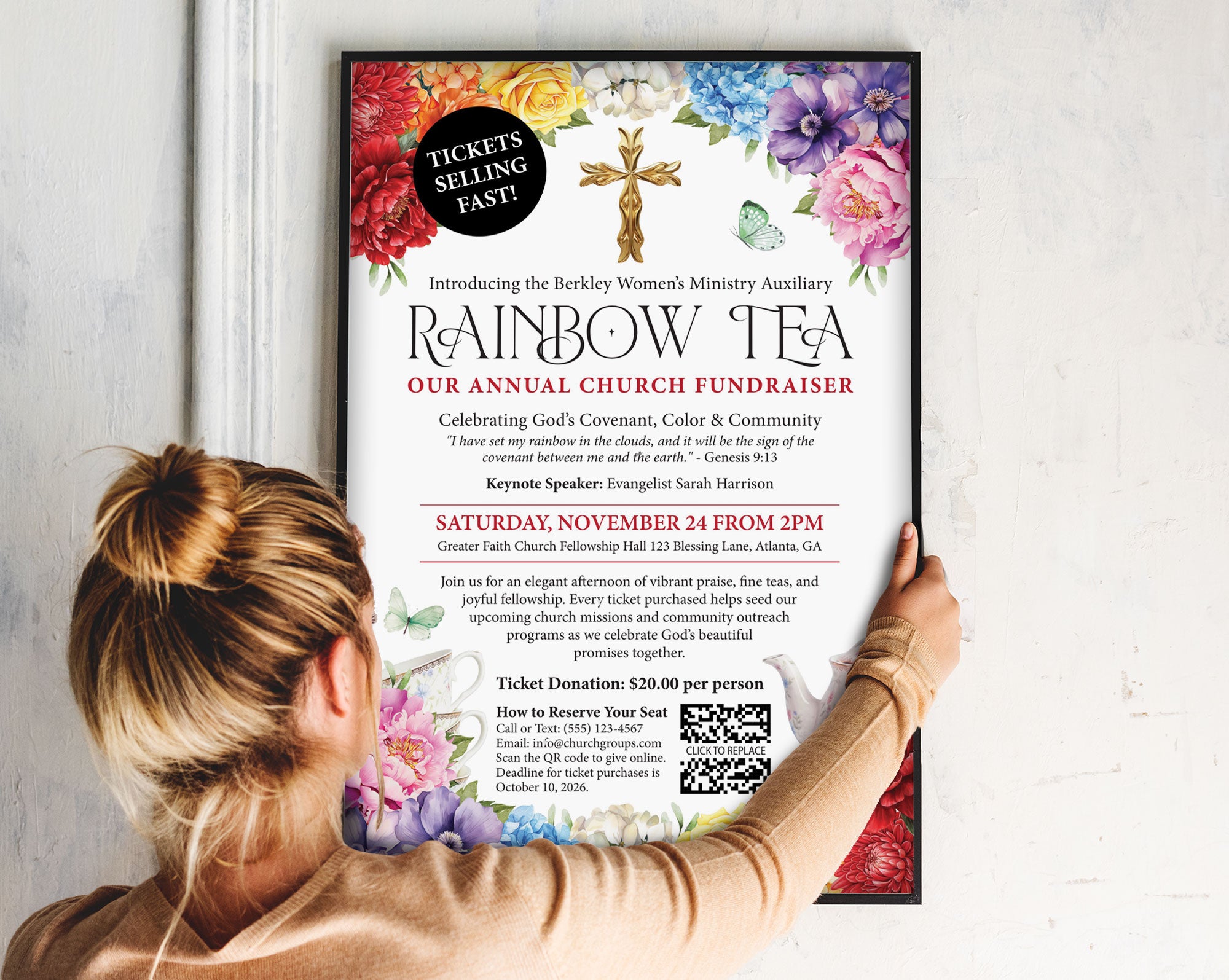 a lady putting up a 12 x 18 church rainbow tea fundraising poster in a black frame on to a wall