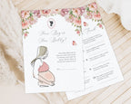 2 blush pink flower baby shower game cards laying on a wooden background next to a cloth and some dried plants