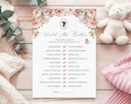 A blush pink baby shower game card titled 'would she rather' laying on a wooden background, next to a white teddy bear, a pink and a white blanket and some eucalyptus leaves