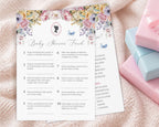 two baby shower game cards, one titled 'baby shower feud' laying on a cream blanket next to some pink and blue wrapped gifts