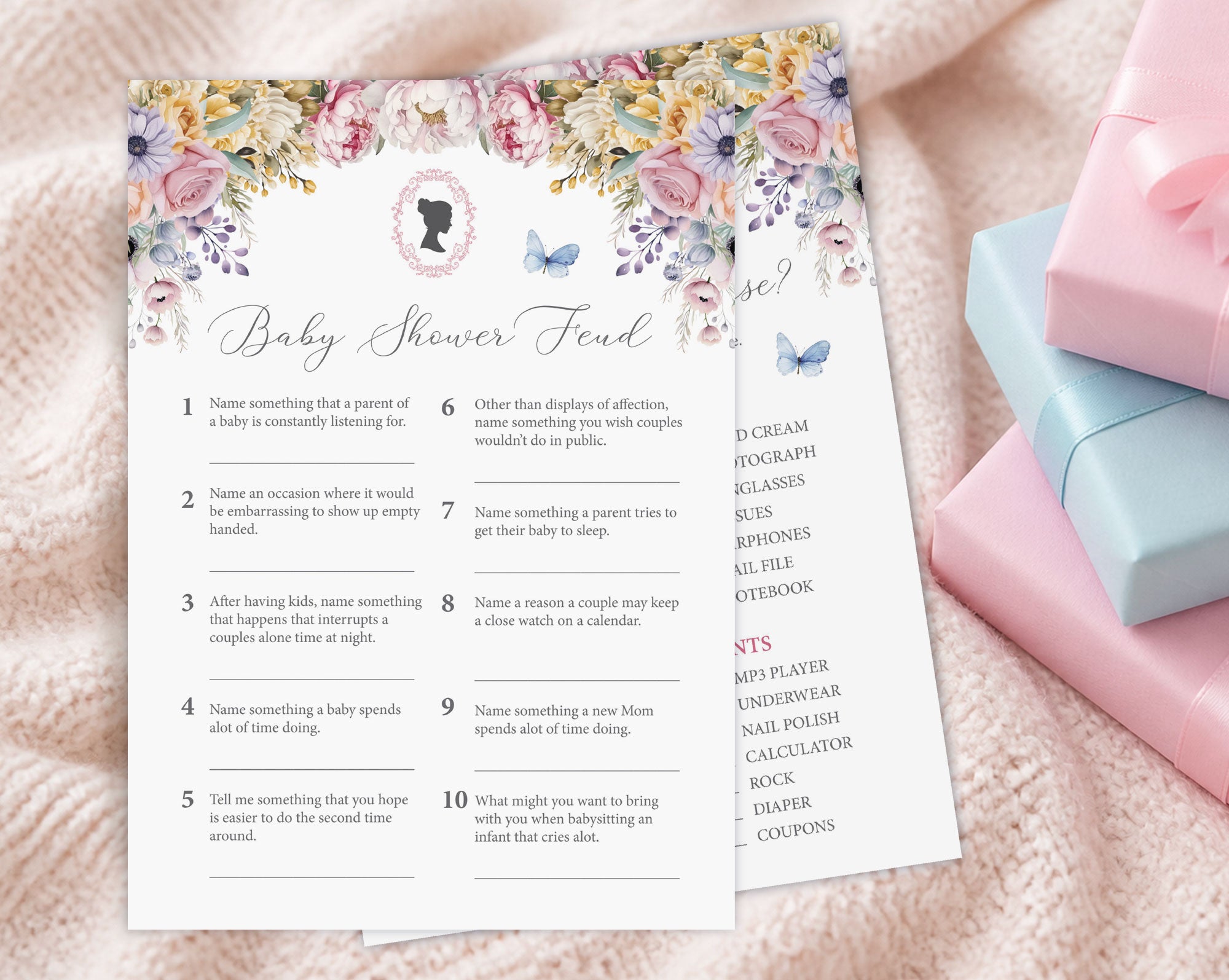 two baby shower game cards, one titled 'baby shower feud' laying on a cream blanket next to some pink and blue wrapped gifts