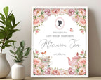 16 x 20 welcome sign for an afternoon tea party in a white frame leaning against a beige wall next to a vase with greenery