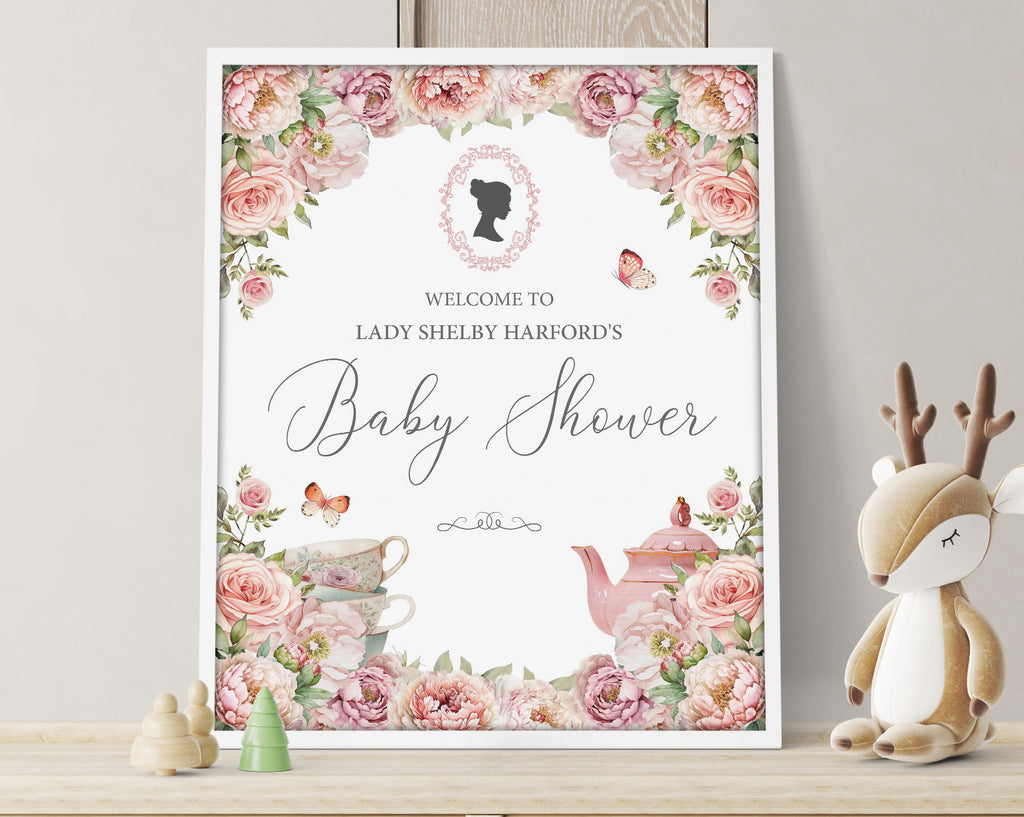 Pretty pink flower 16 x 20 baby shower welcome sign with regency style cameo in a white frame leaning up against a grey wall with a stuffed reindeer toy next to it