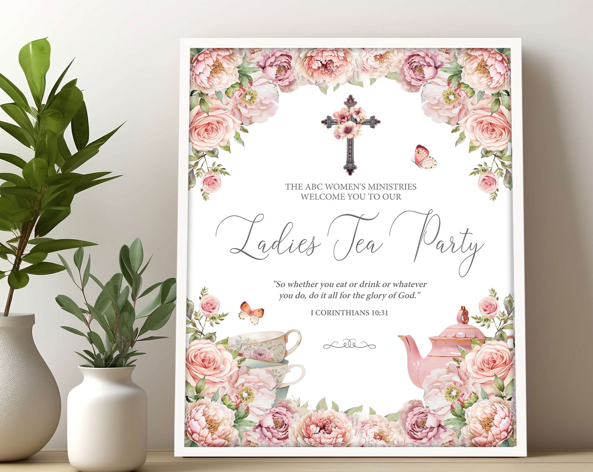 16x20 Church Ladies Tea Welcome Sign in a white frame with blush pink flowers, Christian Cross and Teapot leaning up against a wall next to some greenery in vases