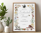 enchanted 16 x 20 sign in a wooden frame with raven, forest animals and flora and fauna, leaning up against a beige wall next to some greenery in vases