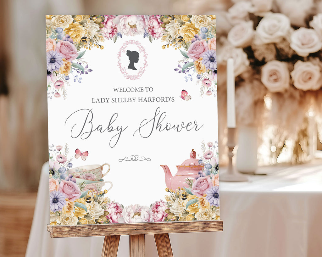 a pastel flower baby shower welcome sign with regency cameo, butterflies and tea set graphics, on a wooden easel, in front of a table with candles and cream flowers