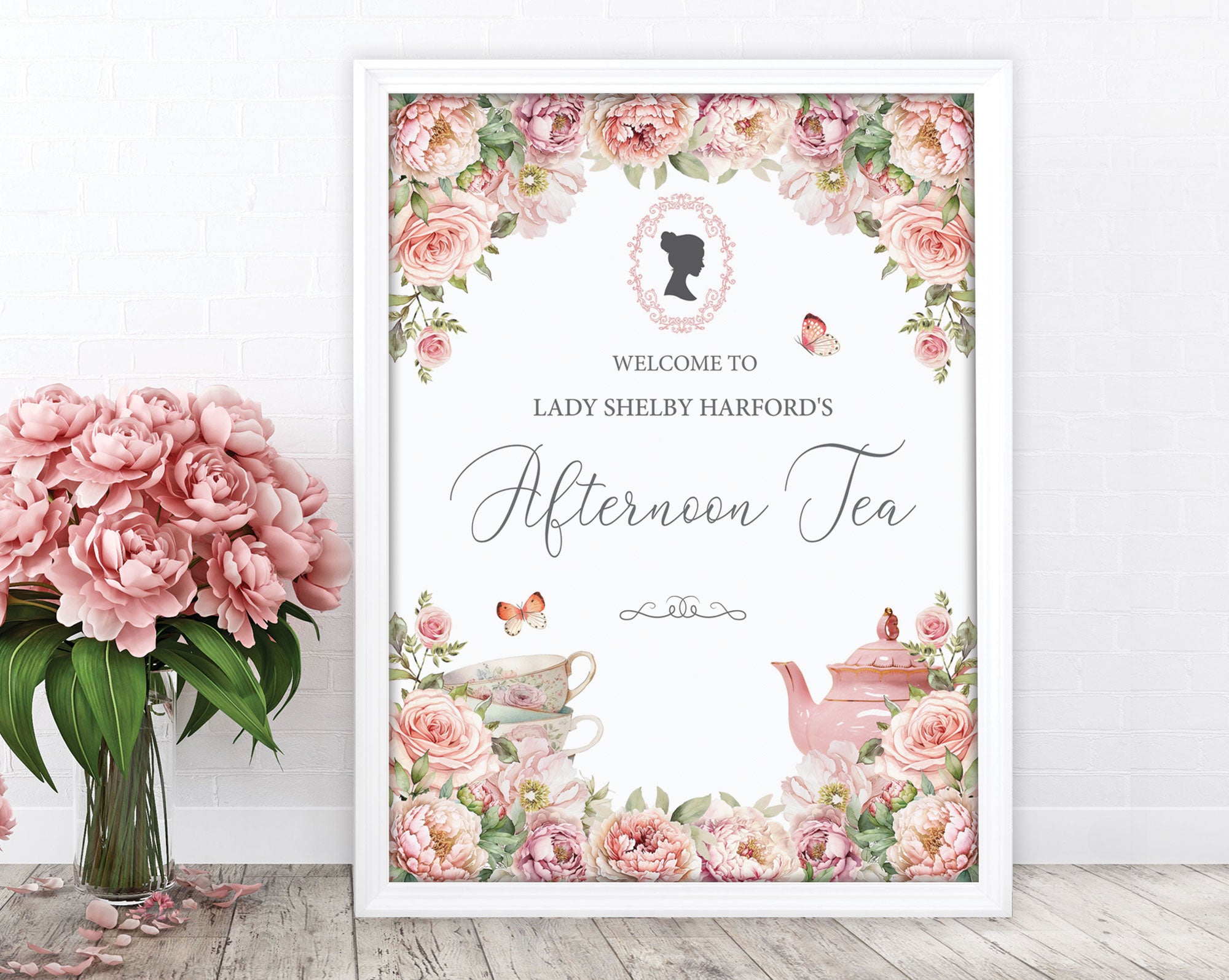 18 x 24 welcome sign for an afternoon tea event with floral design and teacup illustration, leaning against a white wall next to a vase of pink flowers
