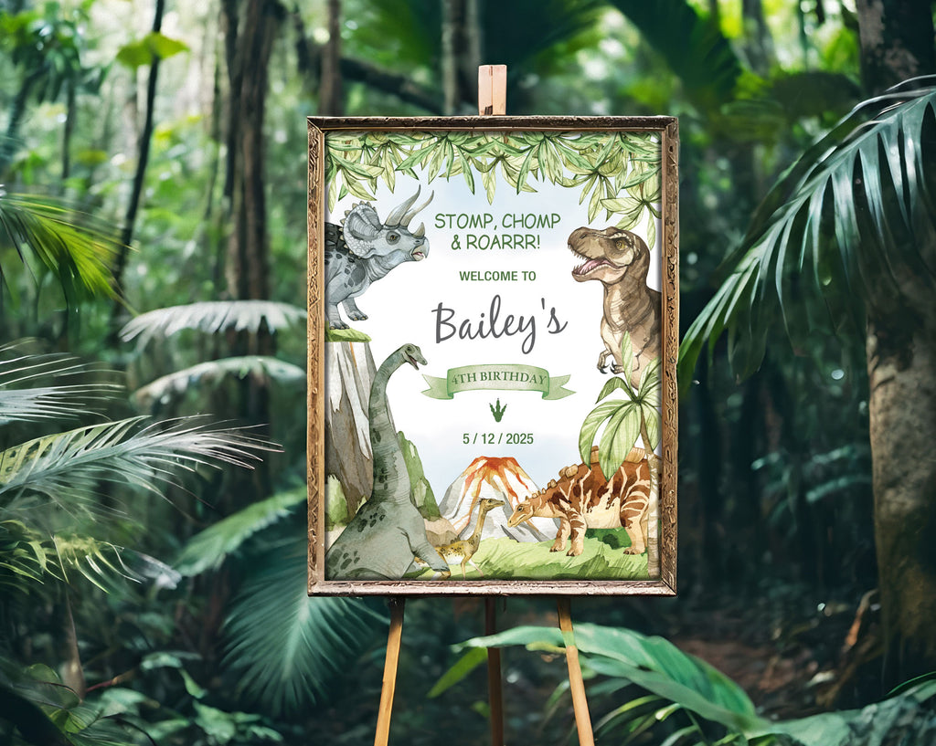 a dinosaur jurassic party sign in a gold frame on an easel with a green lush forest in the background.