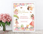 Fairy garden party birthday welcome sign in a white frame leaning up against a white wall next to some pink flowers in a vase