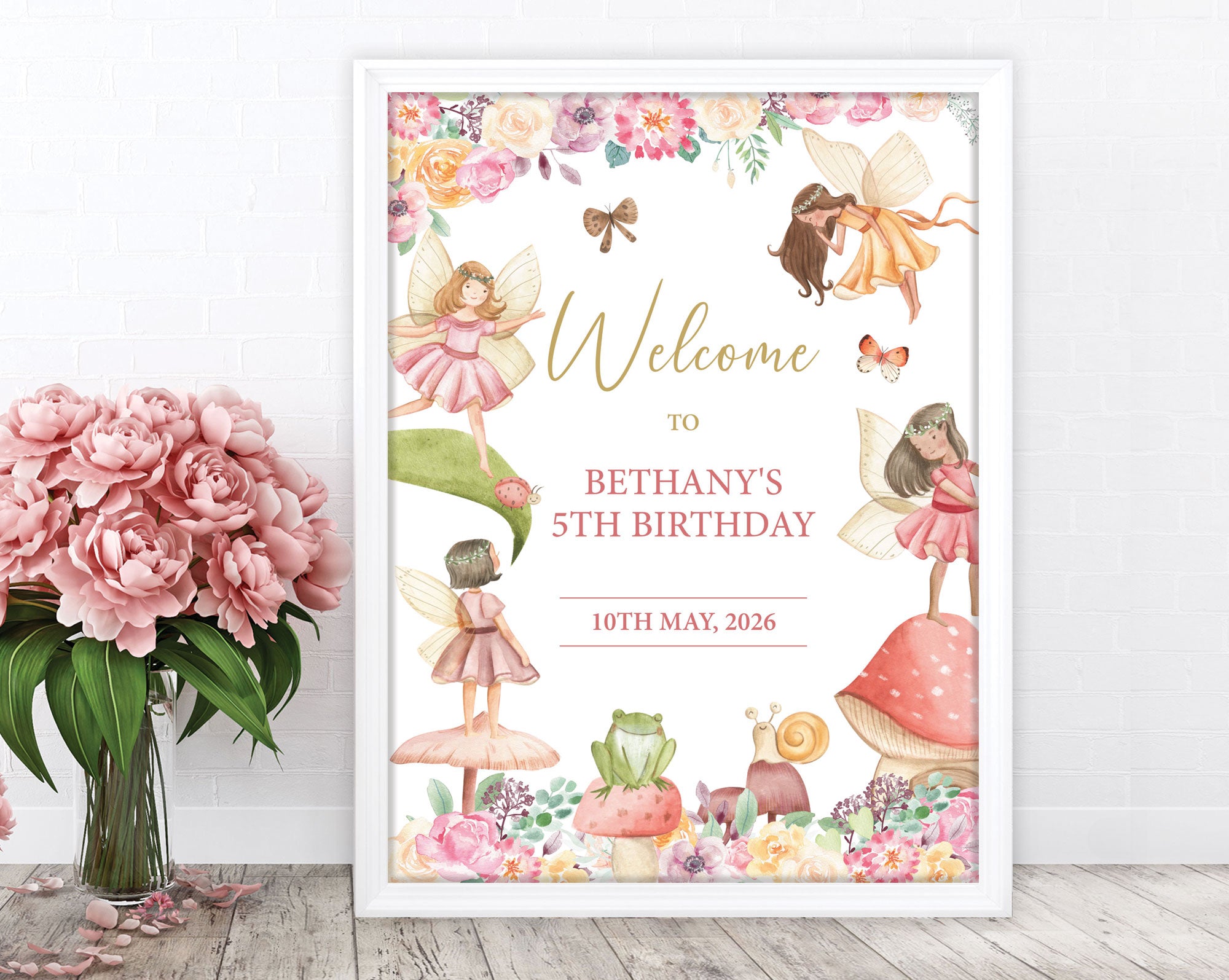 Fairy garden party birthday welcome sign in a white frame leaning up against a white wall next to some pink flowers in a vase
