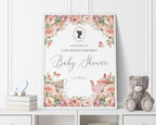 18 x 24 baby shower welcome sign with regency style cameo and blush pink flowers, tea pot and tea cup graphics, in a white frame, leaning up against a white panelled wall next to a grey teddy bear and some books