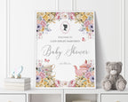 18 x 24 baby shower welcome sign with regency style cameo and pastel flowers, tea pot and tea cup graphics, in a white frame, leaning up against a white panelled wall next to a grey teddy bear and some books