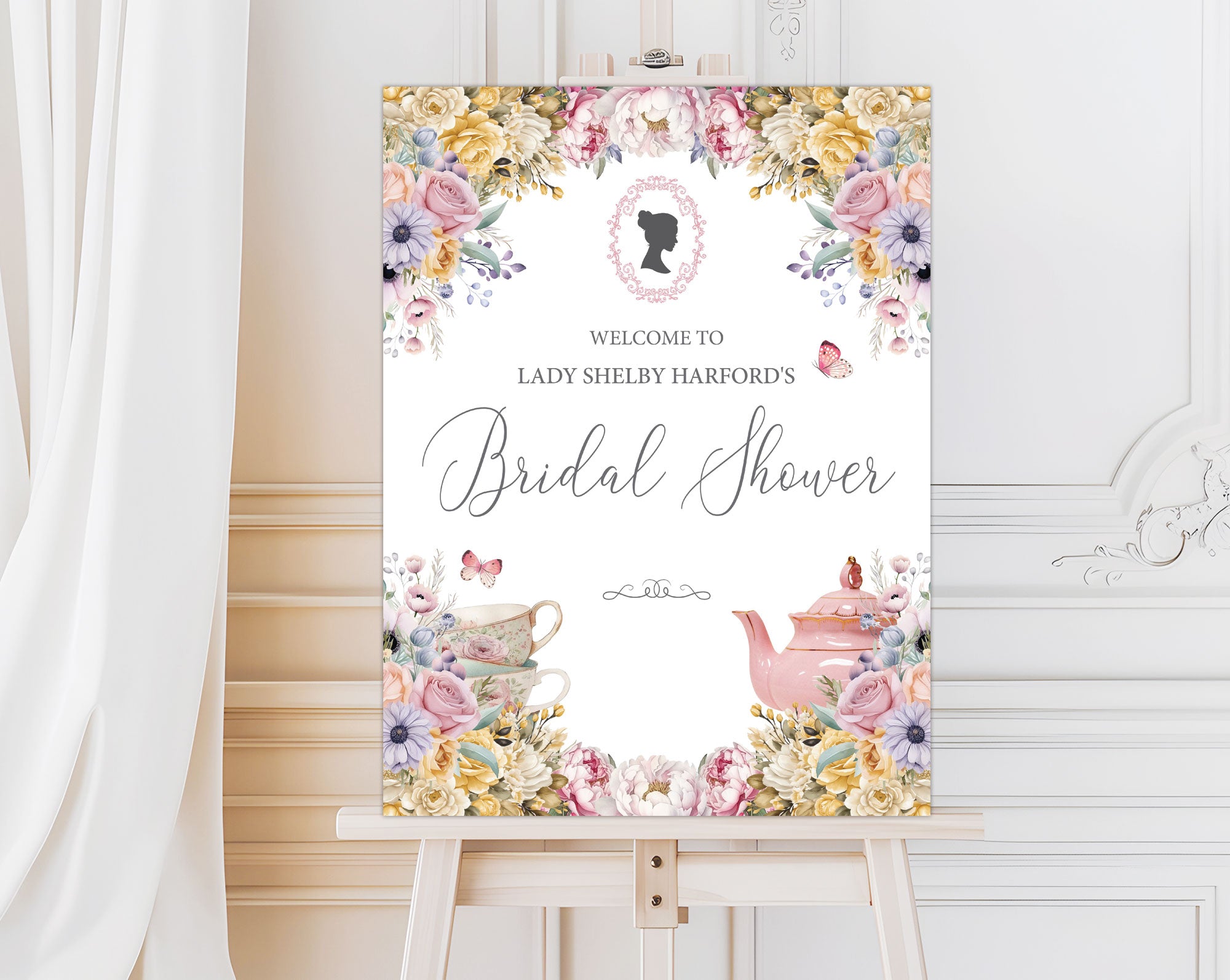 elegant pastel entrance sign for a bridal shower with teapot and cameo on a wooden easel in front of a white panelled wall and curtain