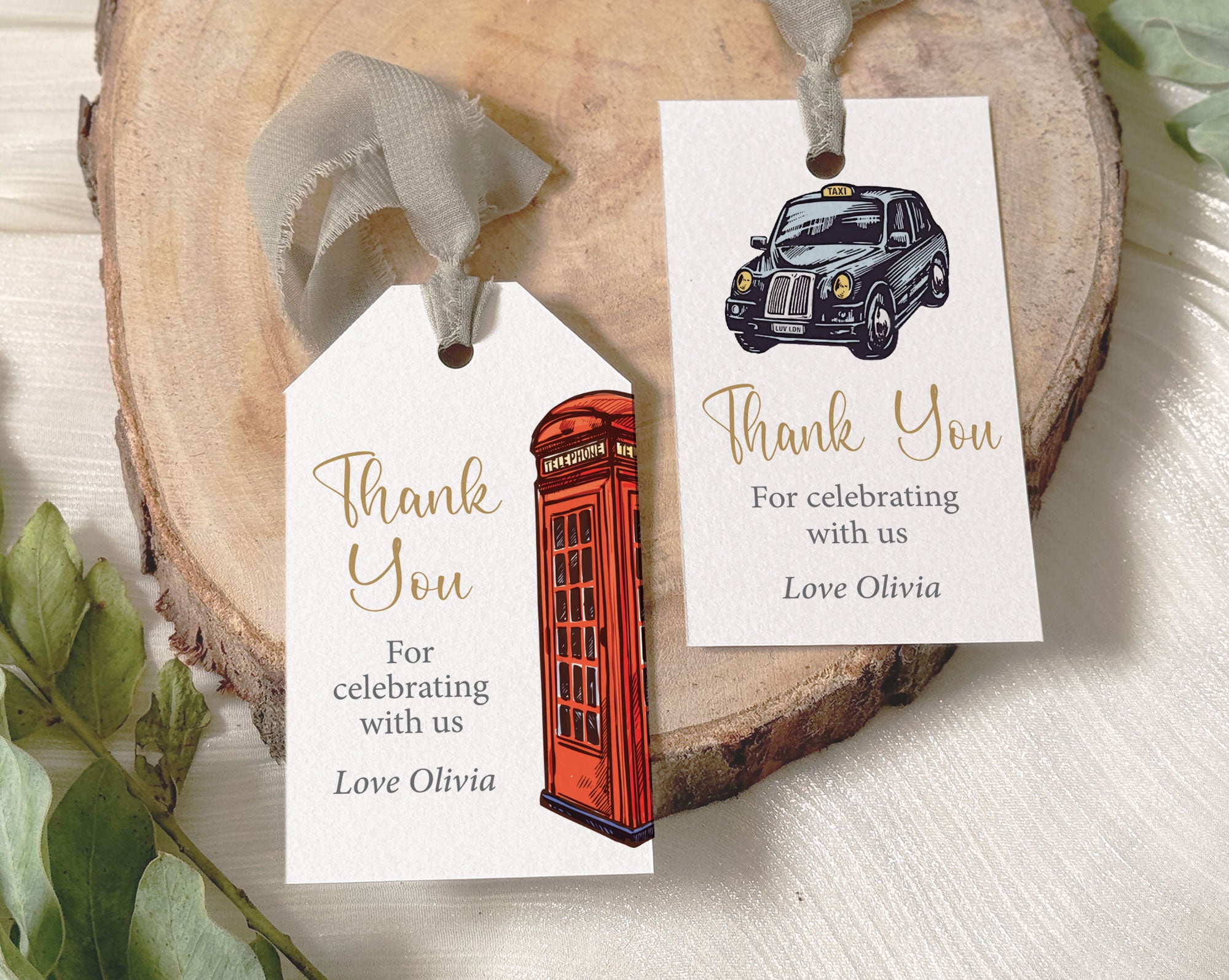two british london icon of telephone box and black cab favor gift tags laying on a tree stump with pretty grey ribbon attached to them