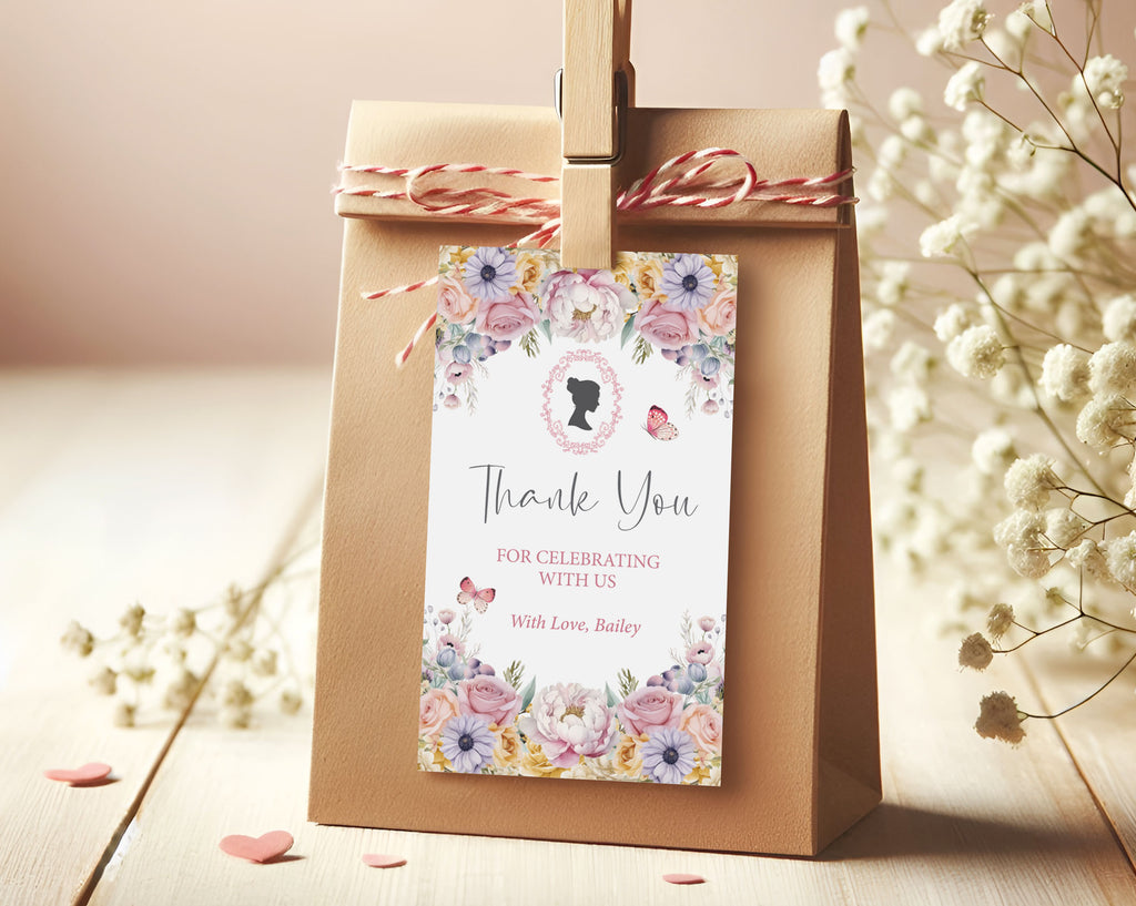 Brown paper bag with pastel flower 'Thank You' card pegged to it sitting on a wooden surface with flowers in the background