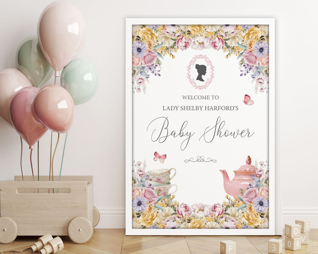 an elegant pastel 18 x 24 baby shower welcome sign in a white frame leaning up against a white wall next to a toy box with balloons tied to it