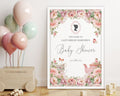 an elegant blush pink 18 x 24 baby shower welcome sign in a white frame leaning up against a white wall next to a toy box with balloons tied to it