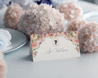 Decorative place card with floral design and text, set against a background of pink hydrangeas.