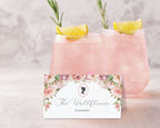 Pink lemonade with rosemary garnish and a decorative label on a light background