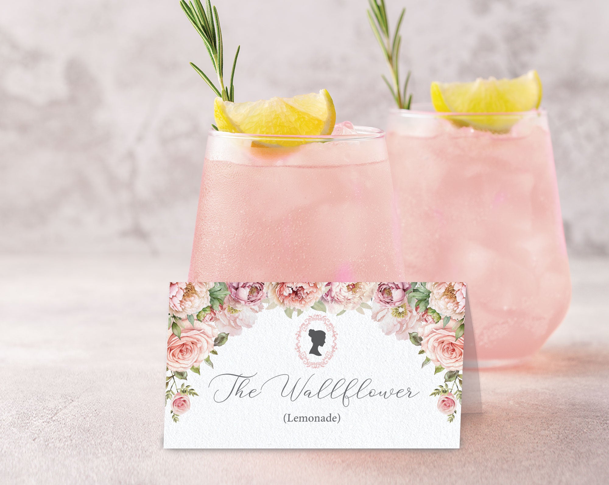 Pink lemonade with rosemary garnish and a decorative label on a light background
