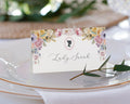 Place card with floral design and 'Lady Carrington' text on a white plate with gold rim.