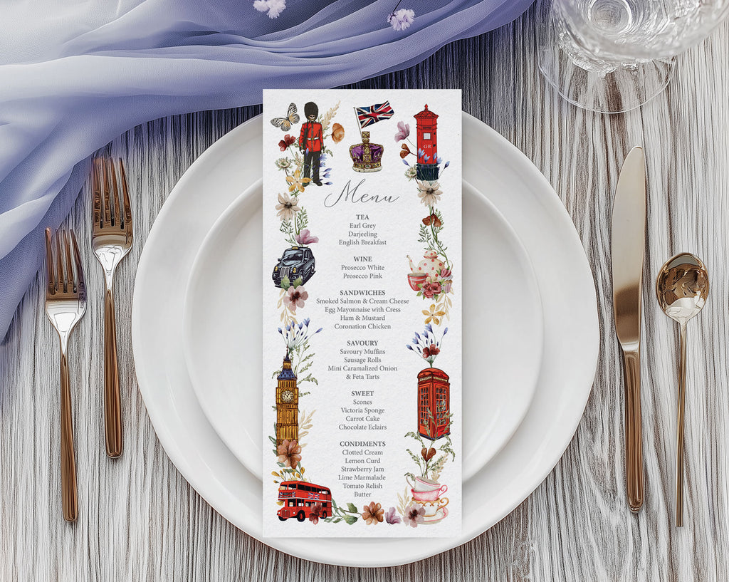 a pretty british icon menu with black cab, big ben, crown, telephone box and double decker bus graphics, laying on a white plate, with cutlery and a blue gauzy cloth above it