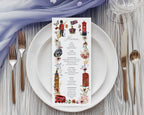 a pretty british icon menu with black cab, big ben, crown, telephone box and double decker bus graphics, laying on a white plate, with cutlery and a blue gauzy cloth above it
