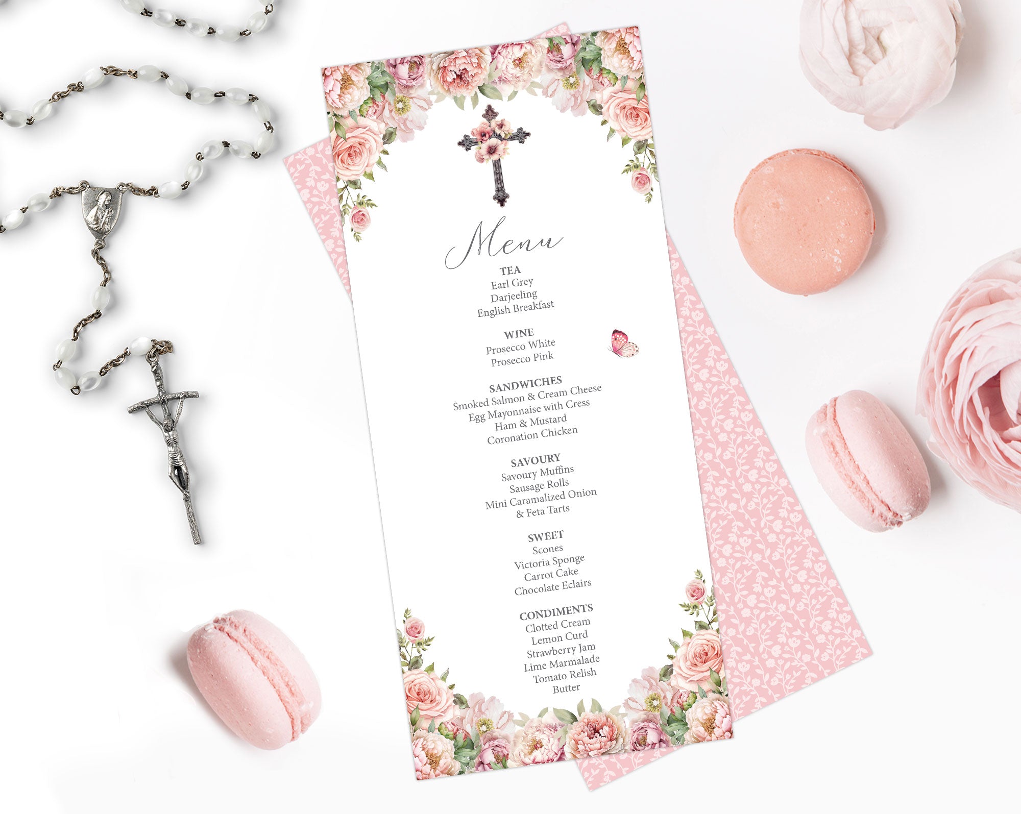 pink flower menu for a church event with cross and pretty pattern back lying on a white background next to a rosary and macarons