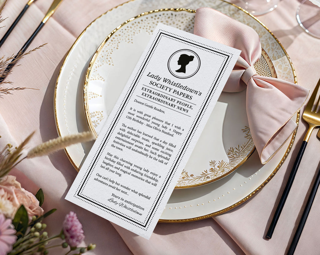 a black and white regency style girls birthday regency style announcement card laying on a gold and white plate with a pink bow and flowers next to it