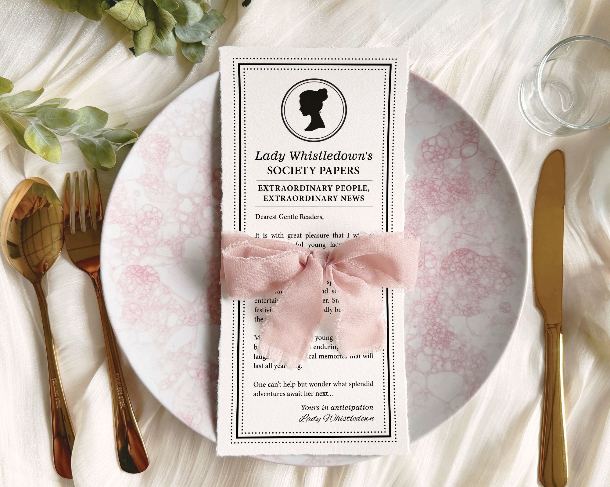 Pretty Dear Gentle Reader Ton Kids birthday Society announcement wrapped in a pink ribbon on a plate sitting on a silk white background with gold fork and knife