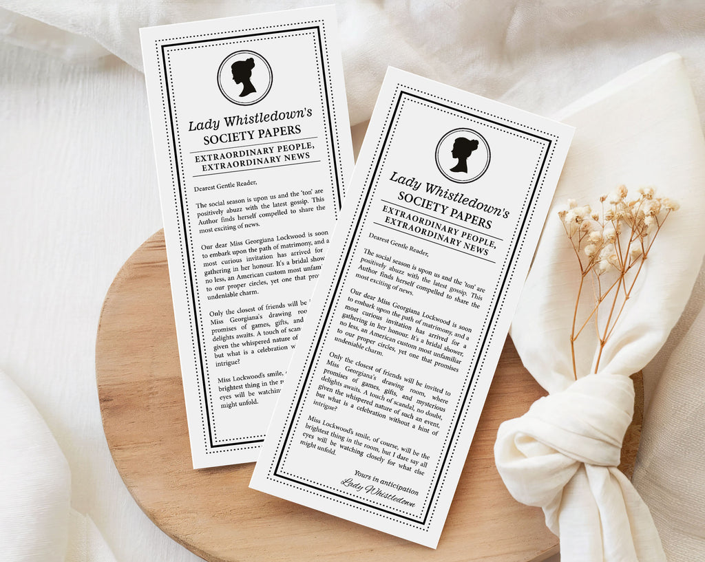 two 'Lady Whistledown's Society Bridal Shower Announcement Papers' on a wooden surface with a white fabric background.