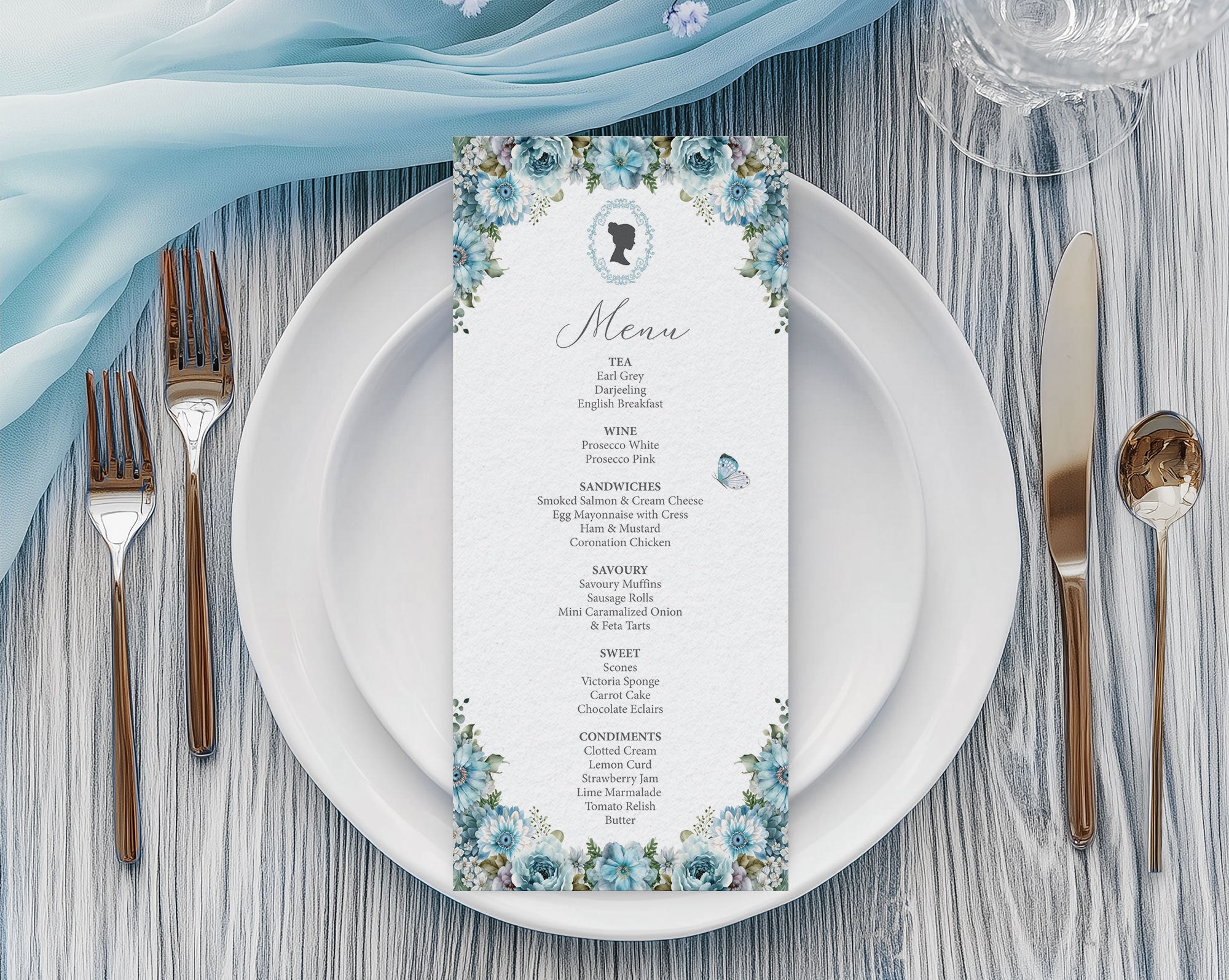 Regency Tea Party Menu with Dusty Blue Flowers, Cameo & Butterfly laying on a white plate with cutlery