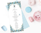 a dusty blue flower regency style tea menu with a cameo lying on a white background next to macarons