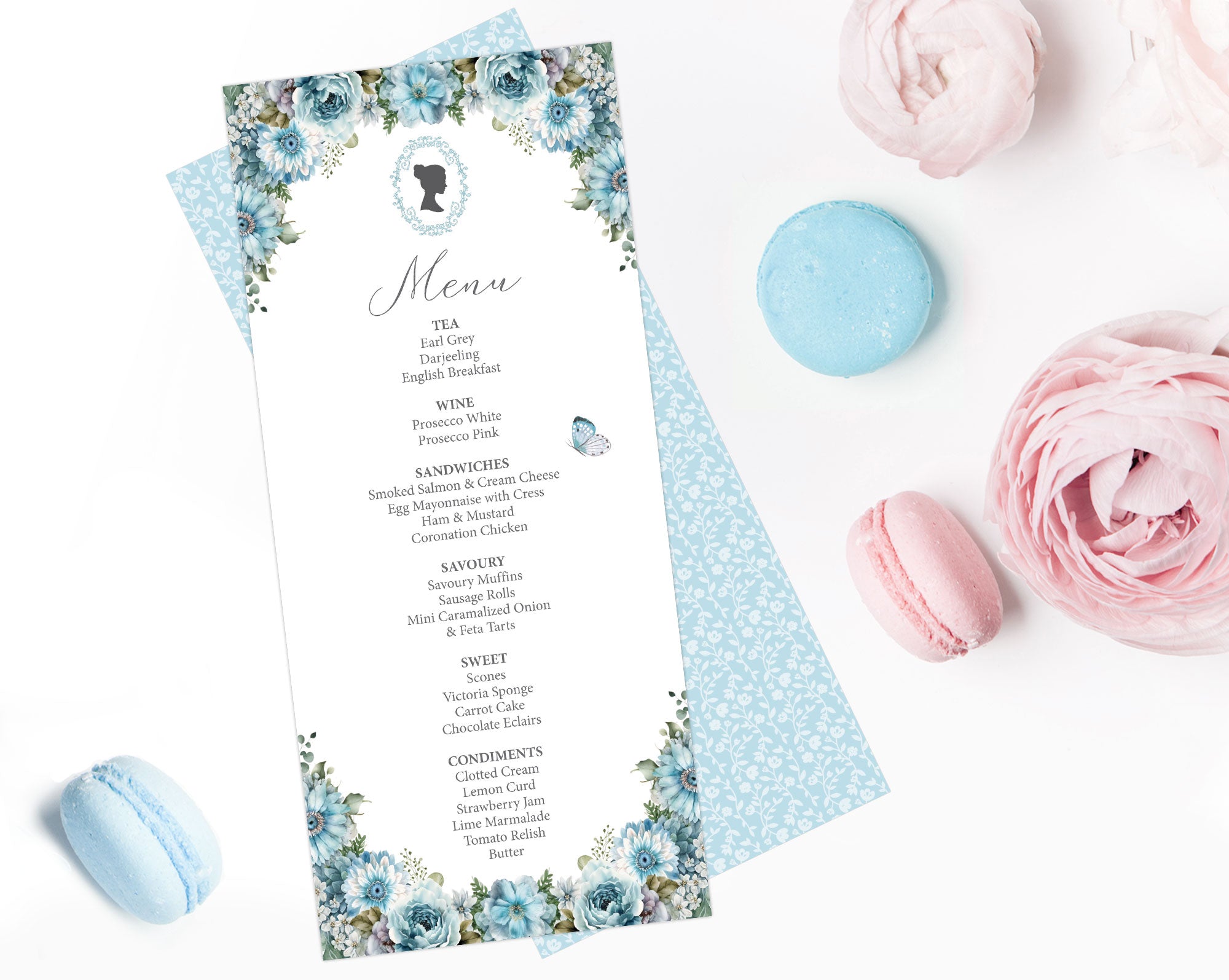 a dusty blue flower regency style tea menu with a cameo lying on a white background next to macarons