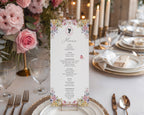 Floral menu card on a elegantly set table with pink roses and candles.