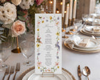 elegant Floral menu card on a table setting with plates, glasses, and candles.
