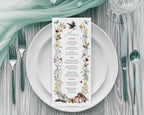 A 4 x 9 Menu for an enchanted forest party with woodland animals and raven graphics laying on a white plate with cutlery