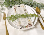 recycled style dinner menu laying on a white plate with greenery across the front and also in the background