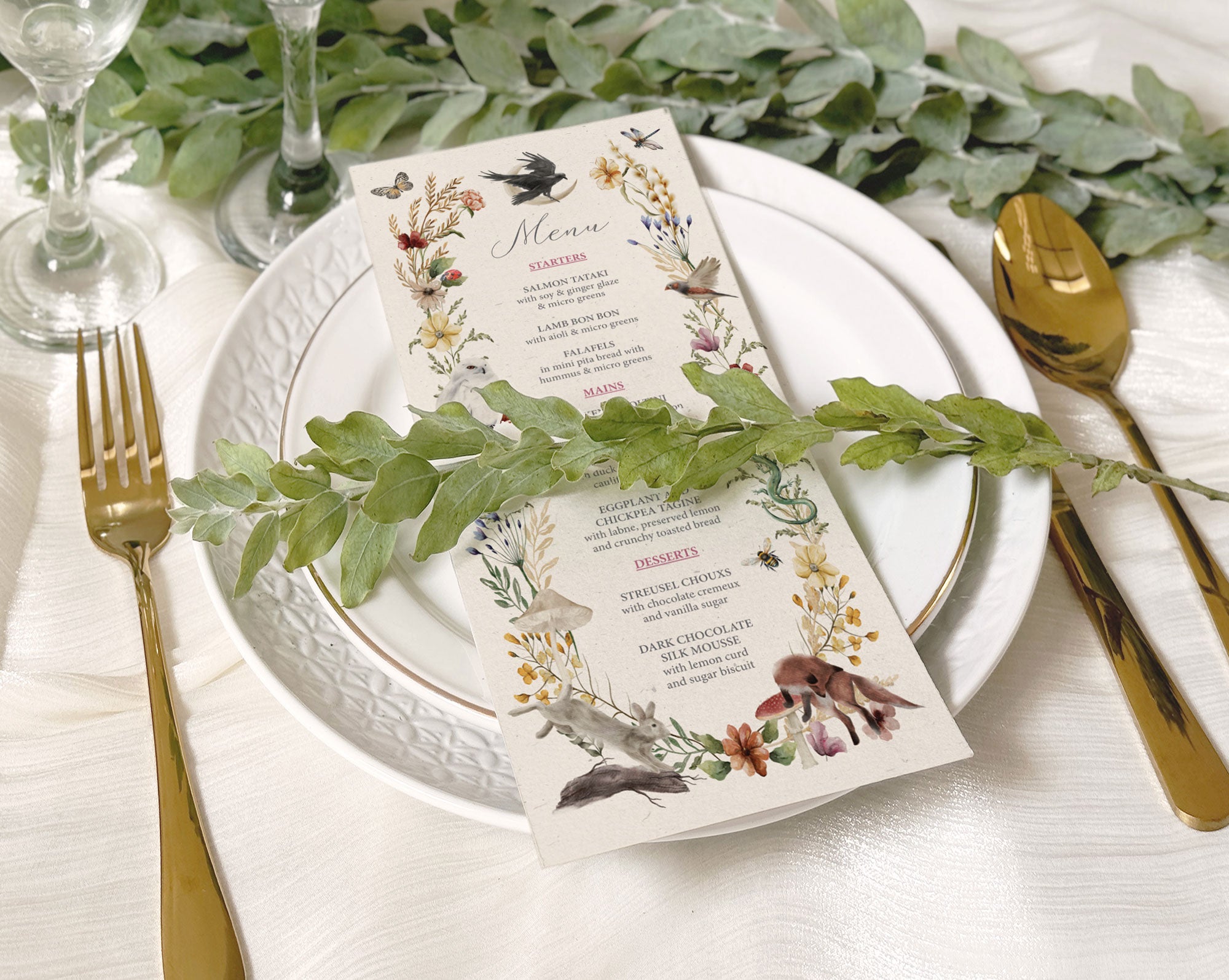 recycled style dinner menu laying on a white plate with greenery across the front and also in the background