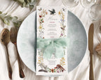 elegant enchanted forest inspired menu with woodland animal graphics, wrapped in a green ribbon, laying on a white plate on a table