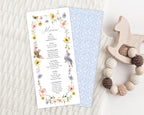 Menu card with floral design and birds with a blue patterned back on a knitted blanket with a teething toy