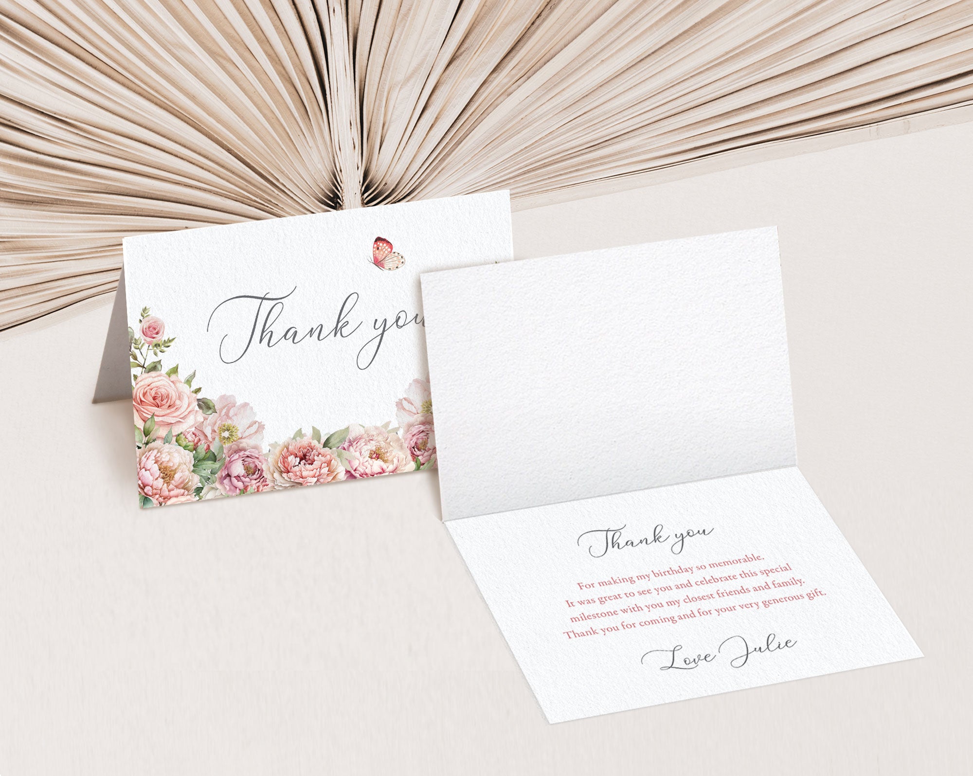 Floral thank you card with another card open to reveal text inside on a neutral background