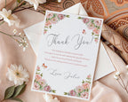 Thank you card with floral design on a textured fabric background with a white envelope