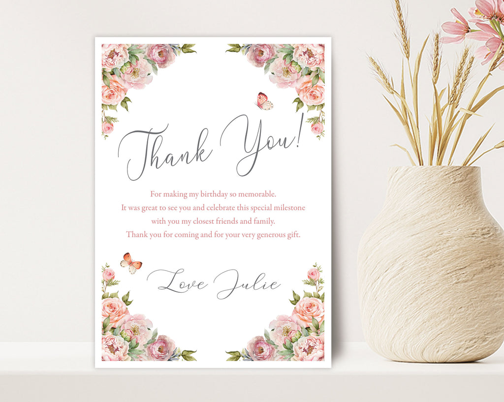 Floral-themed thank you card next to a decorative vase leaning up against a  light beige wall